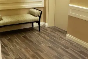 Wood-look porcelain tile transitioning to patterned commercial carpet, elevator lobby