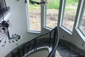 Dark carpet stair runner over wood treads, curved staircase
