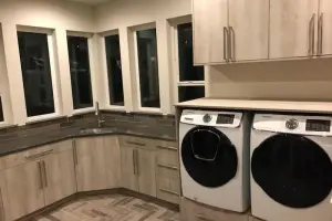 Gray wood-look tile floor in herringbone layout, laundry room